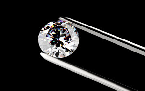 Diamond in the tweezers on a black background